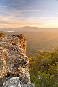 Rock formations on landscape against sky during sunset