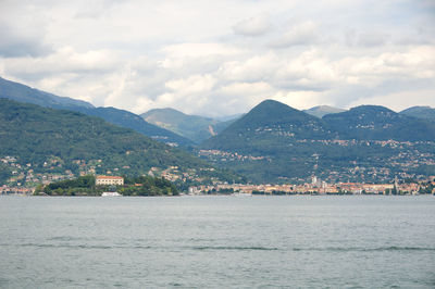 Scenic view of sea by town against sky