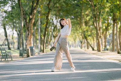 Full length of a young woman walking on road