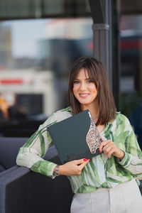 Beautiful young woman with a book in her hands. smiling brunette with a book. 