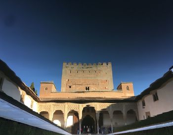 Low angle view of historic building against clear blue sky