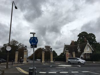 Cars on road against cloudy sky