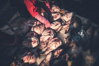 Cropped image of person cutting meat at market for sale