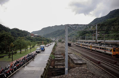 Railroad tracks by mountain against sky