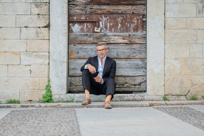 Businessman using mobile phone while sitting outdoors