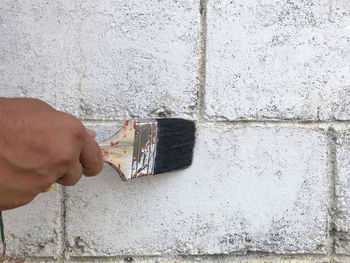 Hand holding window against wall