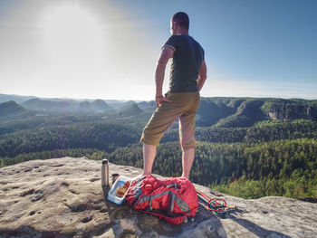 Rear view of man looking at mountains against sky