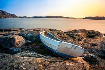 Boat moored on shore against clear sky