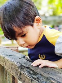 Close-up of boy looking down by railing