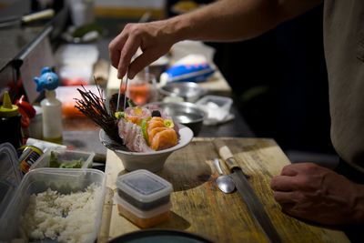 Midsection of man preparing food on table