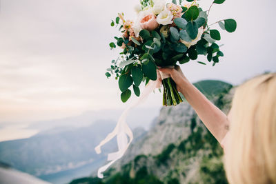 Midsection of woman holding flowering plant