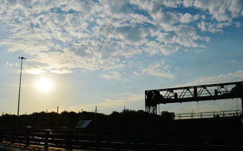 Silhouette of cranes against cloudy sky