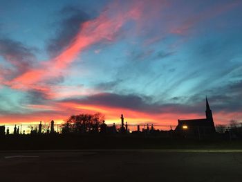 Silhouette buildings against sky at sunset