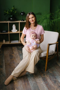 Portrait of young woman sitting on hardwood floor