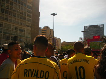 People on street against buildings in city