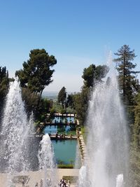 Fountain in sea against clear sky