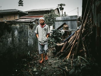 Full length portrait of man standing in abandoned building