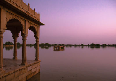 Reflection of building in lake at sunset