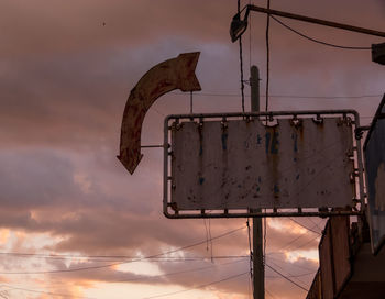 Low angle view of old rusty against sky during sunset