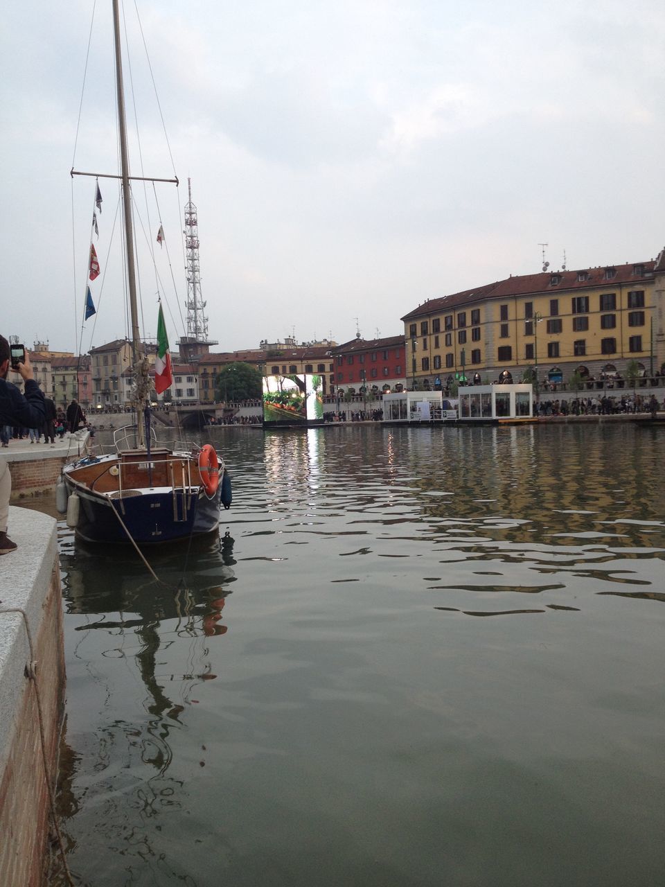 BOAT SAILING IN HARBOR AGAINST SKY