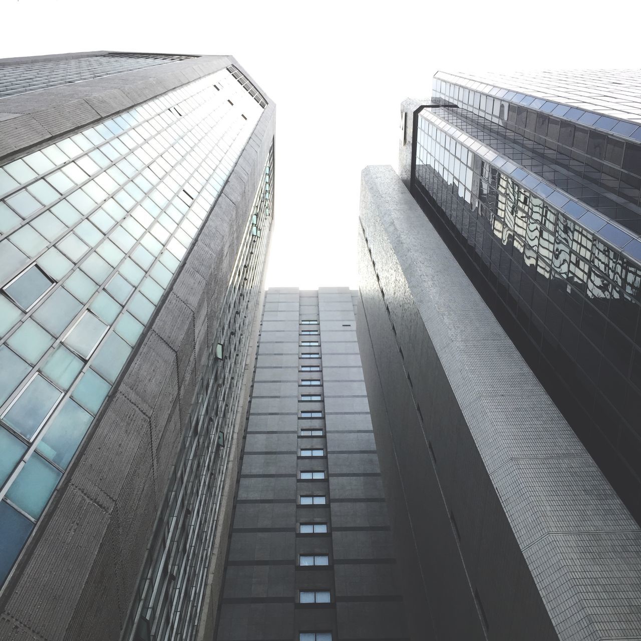 architecture, built structure, low angle view, building exterior, modern, skyscraper, office building, tall - high, city, tower, glass - material, building, clear sky, sky, tall, reflection, day, no people, outdoors, window