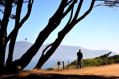 Rear view of man and woman on land against sky