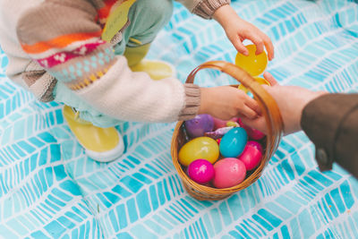 People holding easter eggs in basket
