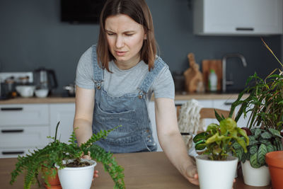 Gardener holding plants at home