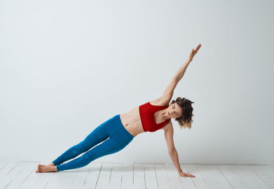 Woman with arms raised against white background