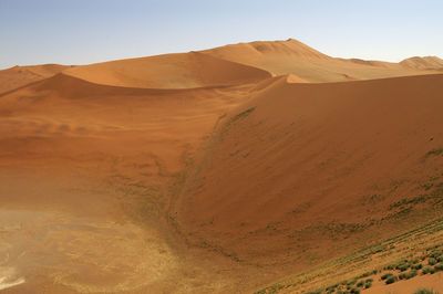Scenic view of sand dunes in desert against sky