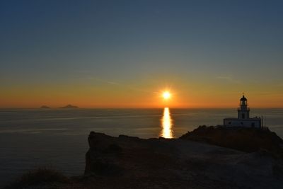 Scenic view of sea against sky during sunset. lighthouse in akrotiri, santorini, greece 