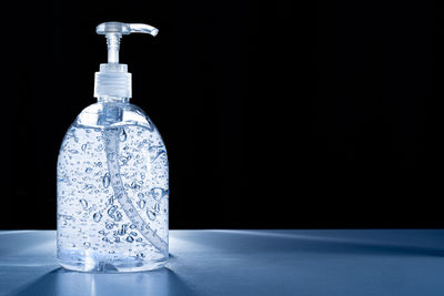 Close-up of water splashing on table against black background