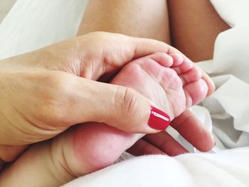 Close-up of mother with baby on bed