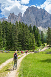 People on footpath against mountains and sky