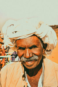 Portrait of smiling man standing outdoors during sunny day