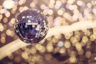 Low angle view of disco ball against christmas lights