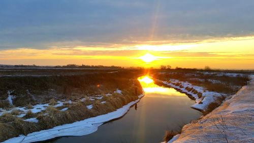 Scenic view of snow against sky during sunset