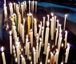 Close-up of illuminated candles in temple