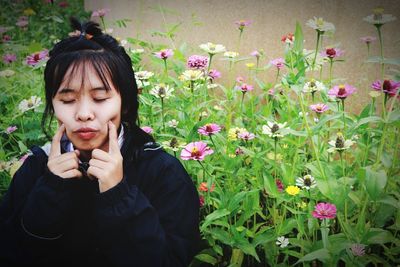 Portrait of beautiful young woman holding flowering plants