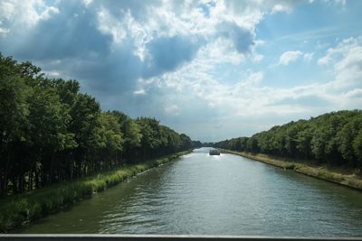 Scenic view of river against cloudy sky