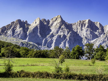 Scenic view of landscape and mountains against clear sky