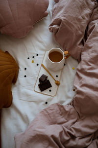 Tea and chocolate on cozy bed