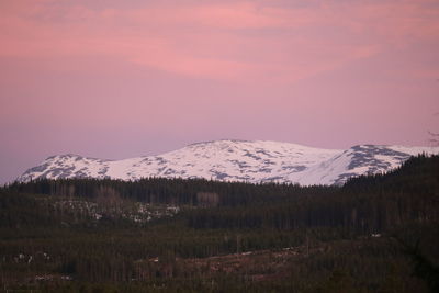 Scenic view of snowcapped mountains against sky at sunset