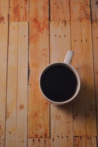 High angle view of coffee cup on wooden table