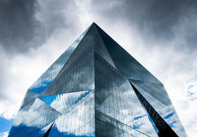 Low angle view of glass building against sky