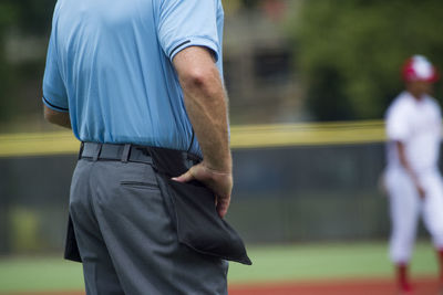 Midsection of referee standing on field