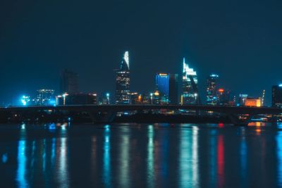 Illuminated bridge over river at night