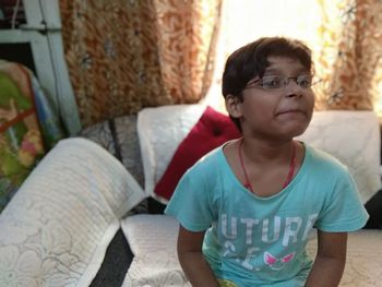 Rear view of boy sitting at home