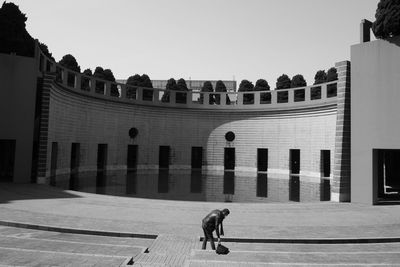 Man walking on street in city against clear sky