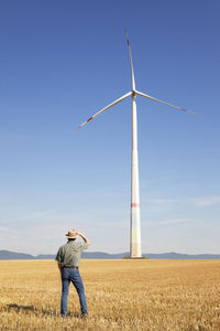 Low angle view of person standing on field against sky